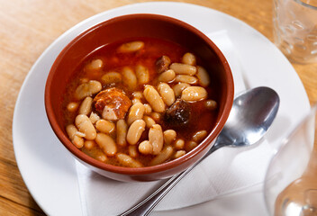 Asturian fabada soup with white beans and blood sausage served in bowl