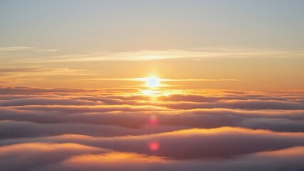 Obraz premium The sky is filled with clouds and the sun is shining brightly. The clouds are white and fluffy, and the sun is casting a warm glow over the scene. Concept of peace and tranquility