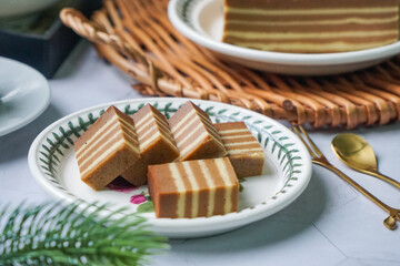 A traditional steamed layer cake with alternating vibrant layers, showcasing a soft, moist texture and rich flavors, perfect for festive occasions.