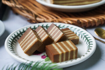 A traditional steamed layer cake with alternating vibrant layers, showcasing a soft, moist texture and rich flavors, perfect for festive occasions.