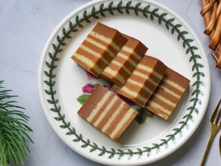 A traditional steamed layer cake with alternating vibrant layers, showcasing a soft, moist texture and rich flavors, perfect for festive occasions.