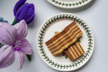 A traditional steamed layer cake with alternating vibrant layers, showcasing a soft, moist texture and rich flavors, perfect for festive occasions.