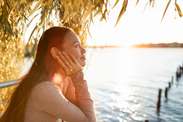Happy young smiling attractive woman feeling at peace in nature sunset 
