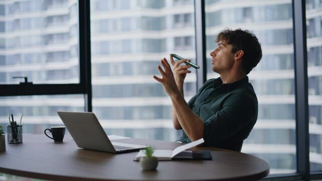 Manager using voice recognition virtual assistant smartphone in office closeup.