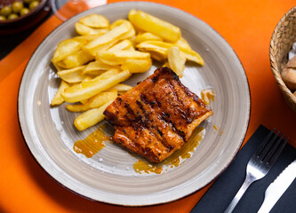 Delicious pork secret served with potatoes on plate in restaurant