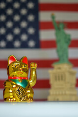 Golden maneki neko beckoning cat and statue of liberty with american flag