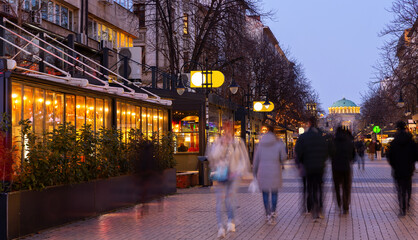 People walk along the evening busy Vitosha Boulevard in the city of Sofia, Bulgaria