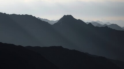 Serene mountain range at dusk with misty silhouettes.
