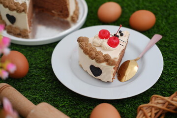 a slice of decorated cake served on a white plate with a gold and pink spoon