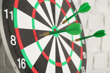 Dart board with arrows on blurred background, closeup
