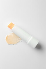 Stick of lip balm and sample on white background, top view