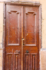 Classic Brown Wooden Double Door with Scratches and Lock in Egyptian Neighborhood