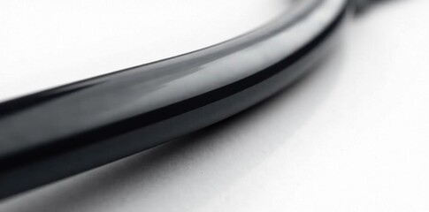 Polished black metallic rod against pure white, photography, minimal