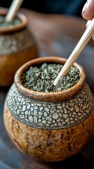 Closeup hands packing yerba mate into traditional gourd with bombilla straw  