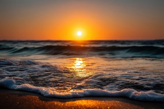 Scenic sunset over ocean waves with golden orange sky reflected on water and rocky shore showing the dramatic natural landscape captured in high resolution twilight photo