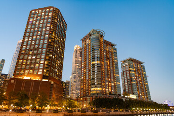 Fototapeta premium Business skyscraper at night. Skyscraper in city downtown. City architecture. Office building in business district. Modern glass building. Chicago night city. Night cityscape of Chicago skyscraper