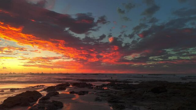 Dramatic sunset cloudscape aerial showing the vibrant colored clouds and ocean waves with coastline in Tamarindo, Costa Rica