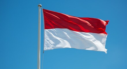 Red and White Flag Flying Against a Clear Blue Sky