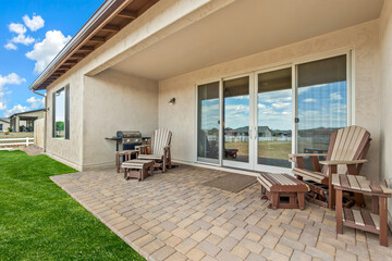 A patio featuring chairs and a table situated in front of a house