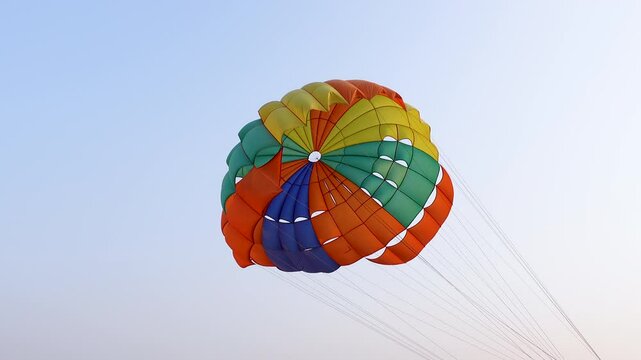 A parasailing wing flying in the sea breeze. An Open colorful parasol canopy flying on the beach in Cox's Bazar.