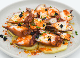 Pulpo a la plancha con salsa, pimentón y patatas cocidas