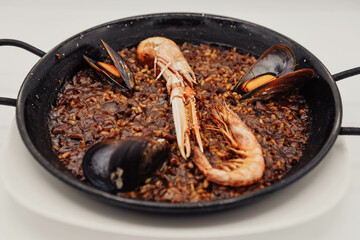 Paella de marisco en una sartén sobre un fondo blanco