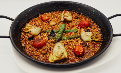 Paella vegetariana con espárragos, tomate y champiñones - estilo comida italiana