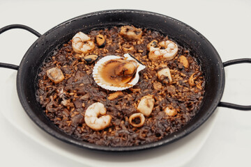 Paella de marisco con una vieira en una marisquería