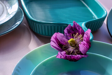 Serving utensils in turquoise color. Poppy flower in bright purple color. Utensils in turquoise...
