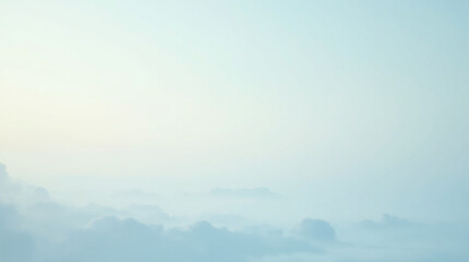 Serene morning mist blankets the landscape in soft, pale blue hues, creating a peaceful and ethereal atmosphere.