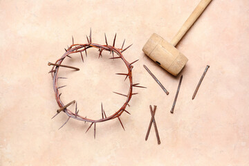 Crown of thorns with nails and mallet on beige background. Good Friday concept