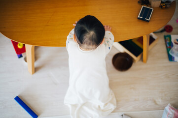 つかまり立ちをする赤ちゃんの後ろ姿