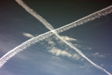 Two plane trails cross in the sky.