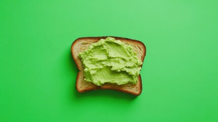 A slice of bread topped with creamy green avocado spread on a vibrant green background, highlighting healthy eating for modern lifestyles.