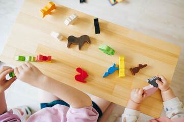 木製のフィギュアで遊ぶ子どもの手