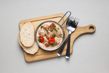 Meatballs in a metal bowl with bread on a wooden board