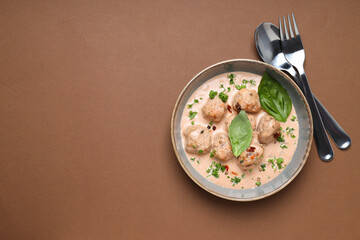 Meatballs in a bowl on a brown background