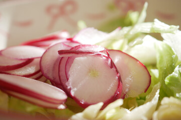 Freshly sliced radishes on a bed of crisp lettuce for a healthy salad