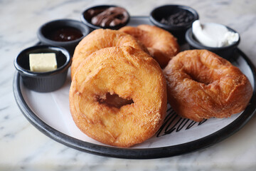 Freshly made donuts served with various dipping sauces