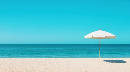 Serene Beach Scene with White Umbrella and Calm Turquoise Waters Under Clear Blue Sky