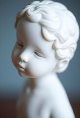 close up of a small white statue of a baby