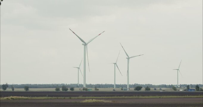 Wind turbines rotating in cloudy day generating green energy