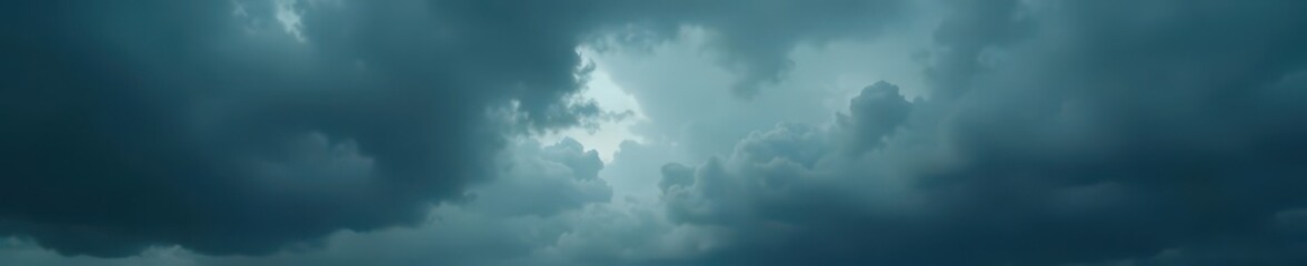 Heavy, dark gray clouds dominate a somber sky ,  somber sky,  weather photography