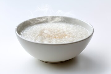 Comforting warm congee in a white bowl emitting steam perfect for healthy breakfast and soft food diet