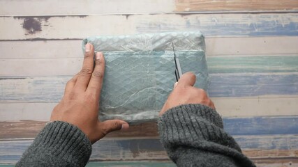 Unboxing a package with excitement and curiosity in a cozy setting