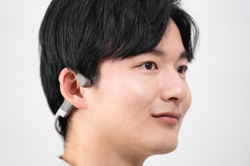 Obraz premium ワイヤレスイヤホンで音楽を聴く若い男性