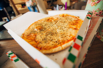 A scrumptious and mouthwatering Cheese Pizza packaged in a Takeout Box