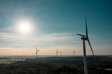 Drone aerial view with wind turbine and the bright sun in the sky, in Baden Wurttemberg region, Germany