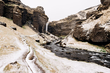 A scenic winter landscape with a waterfall and flowing river
