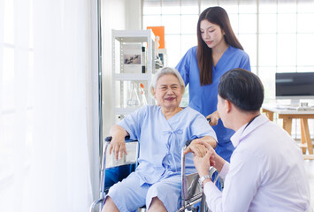 Obraz premium Asian old woman sitting smile with doctor and caring nurse near window in nursing home hospital, consultation caregiver helping support healthcare to elderly senior medicals recovery service wellness.